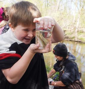 A third grade student says a final good bye to the salmon they've been raising in the classroom.
