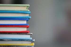 Stack of colorful books with visible spines and varying colors.