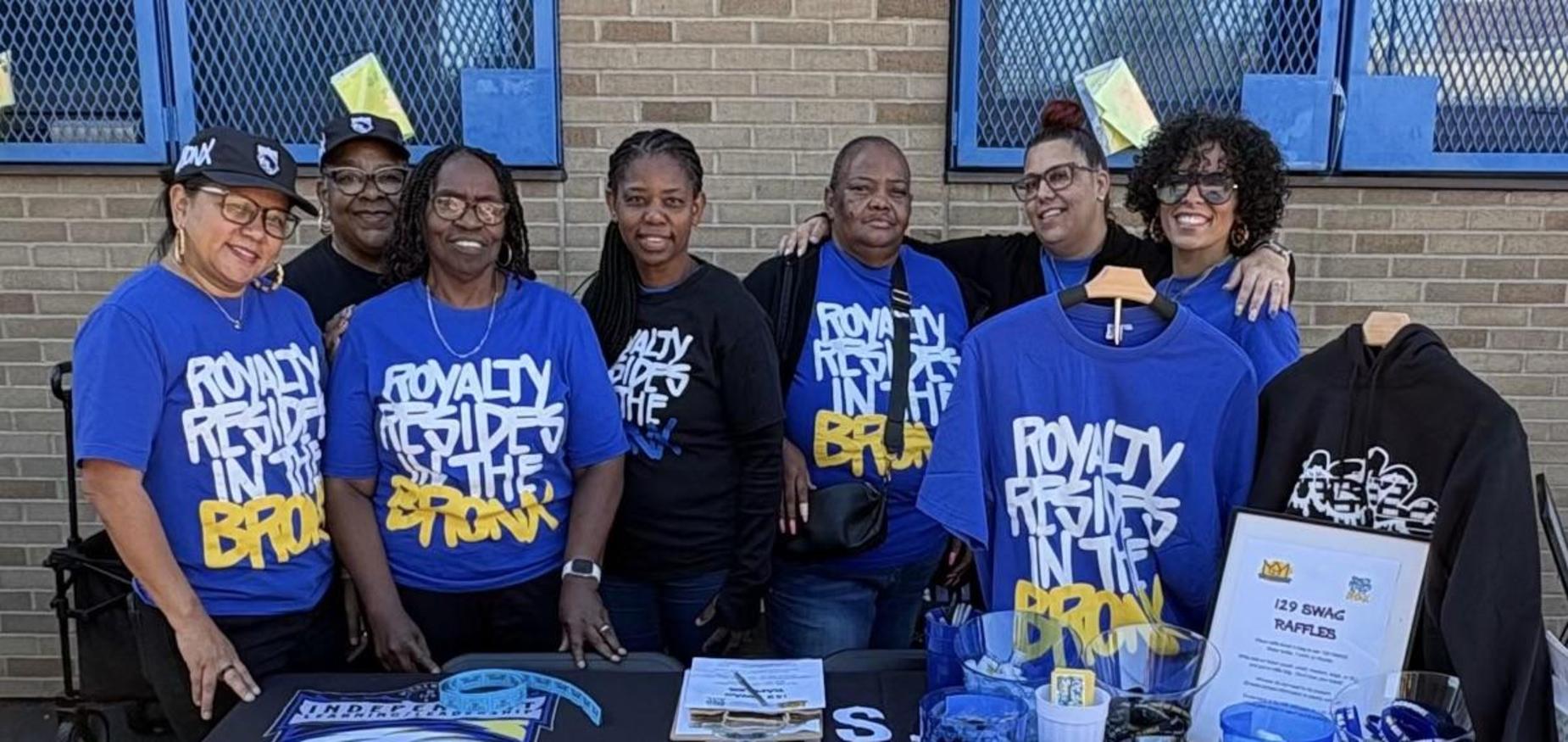 seven people standing together behind a table for MS 129