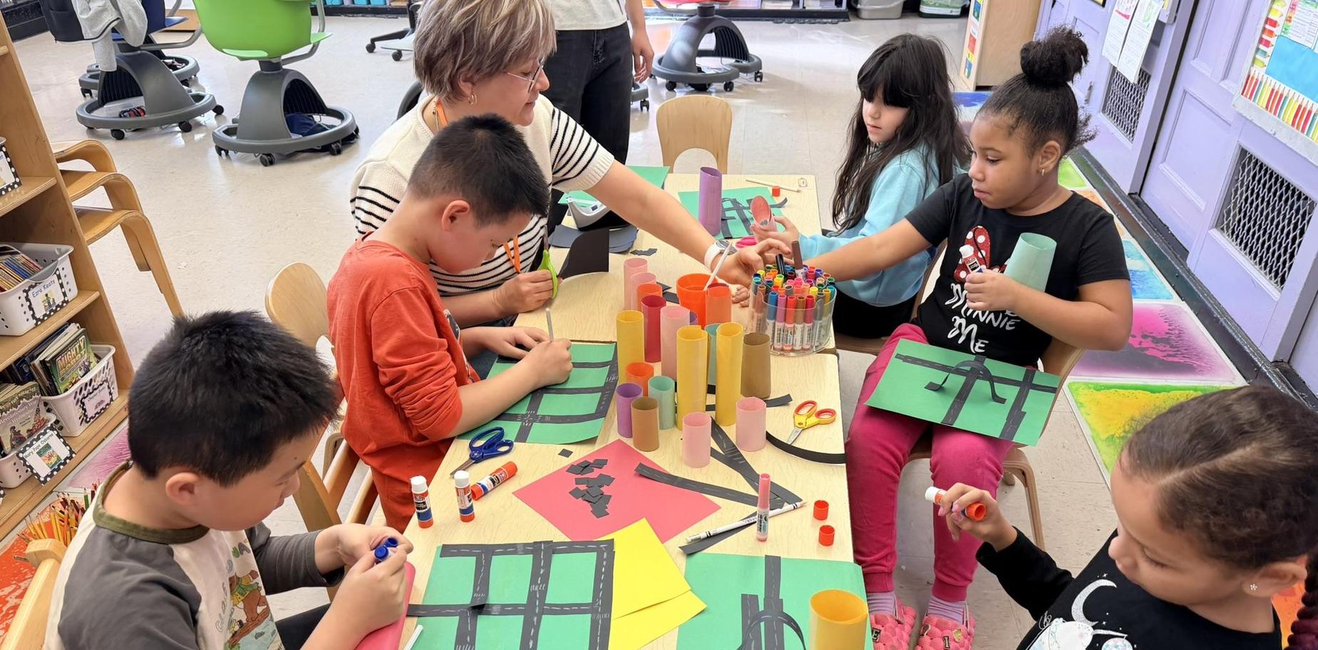 Children engaged in a creative art activity at a classroom table.