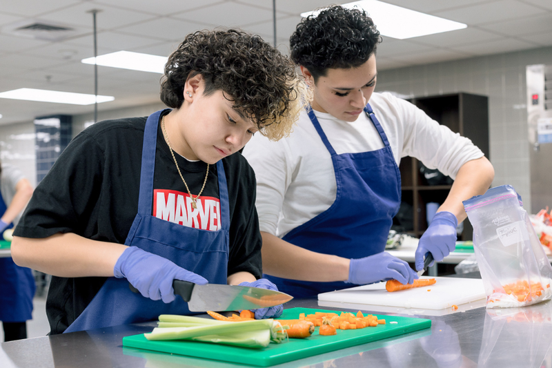 MHS Students in culinary lab, chopping veggies.