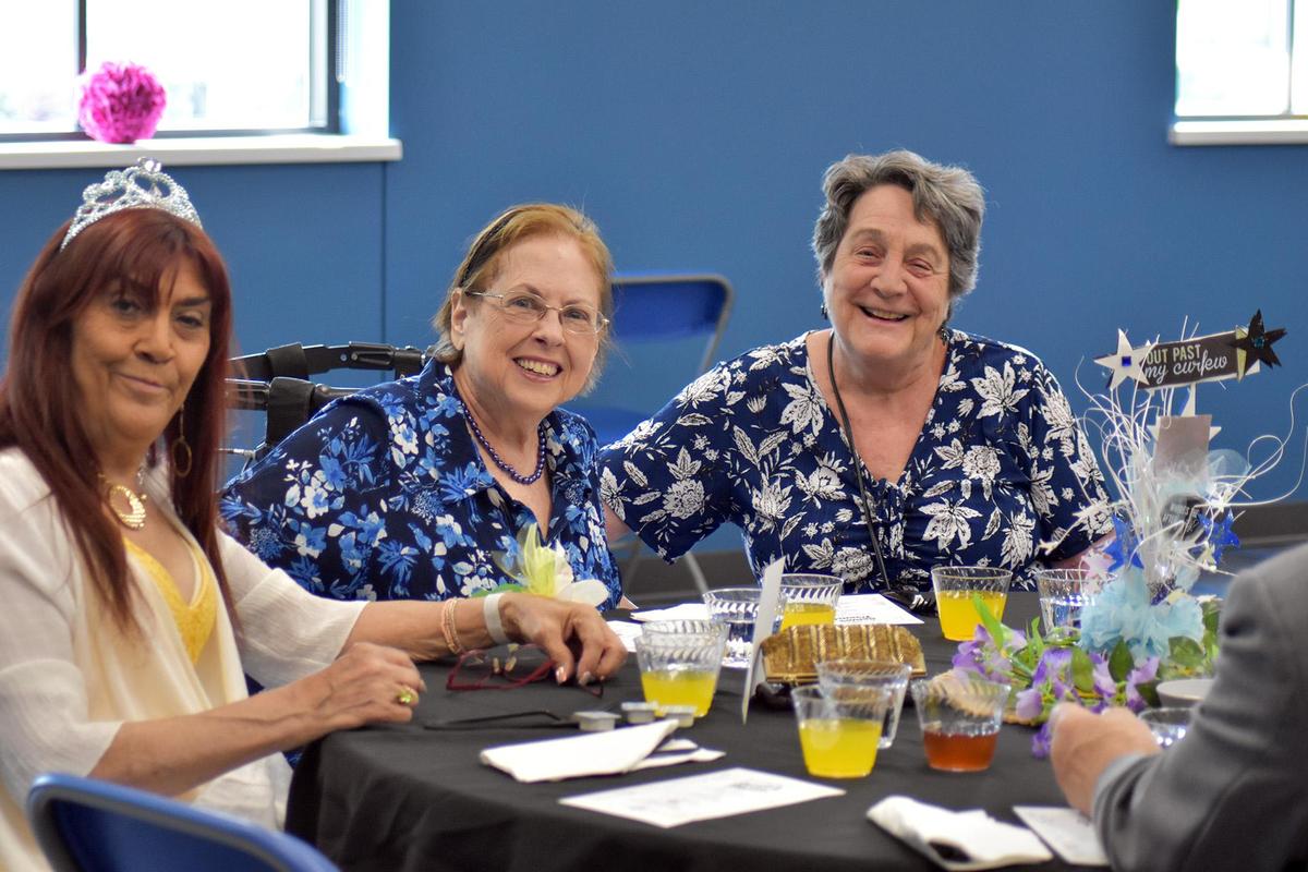 Senior prom women sitting and smiling around table