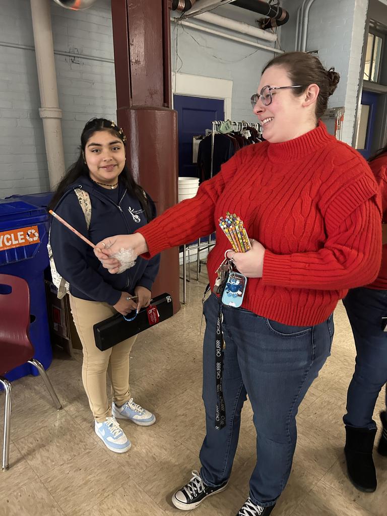 teacher handing student a pencil