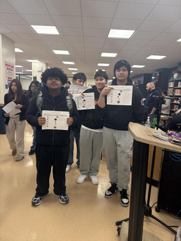 students holding up papers