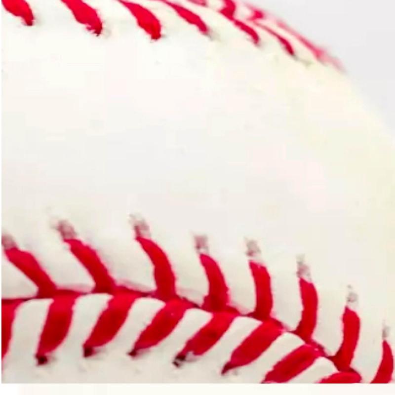 Close-up of a white baseball showing red stitching.