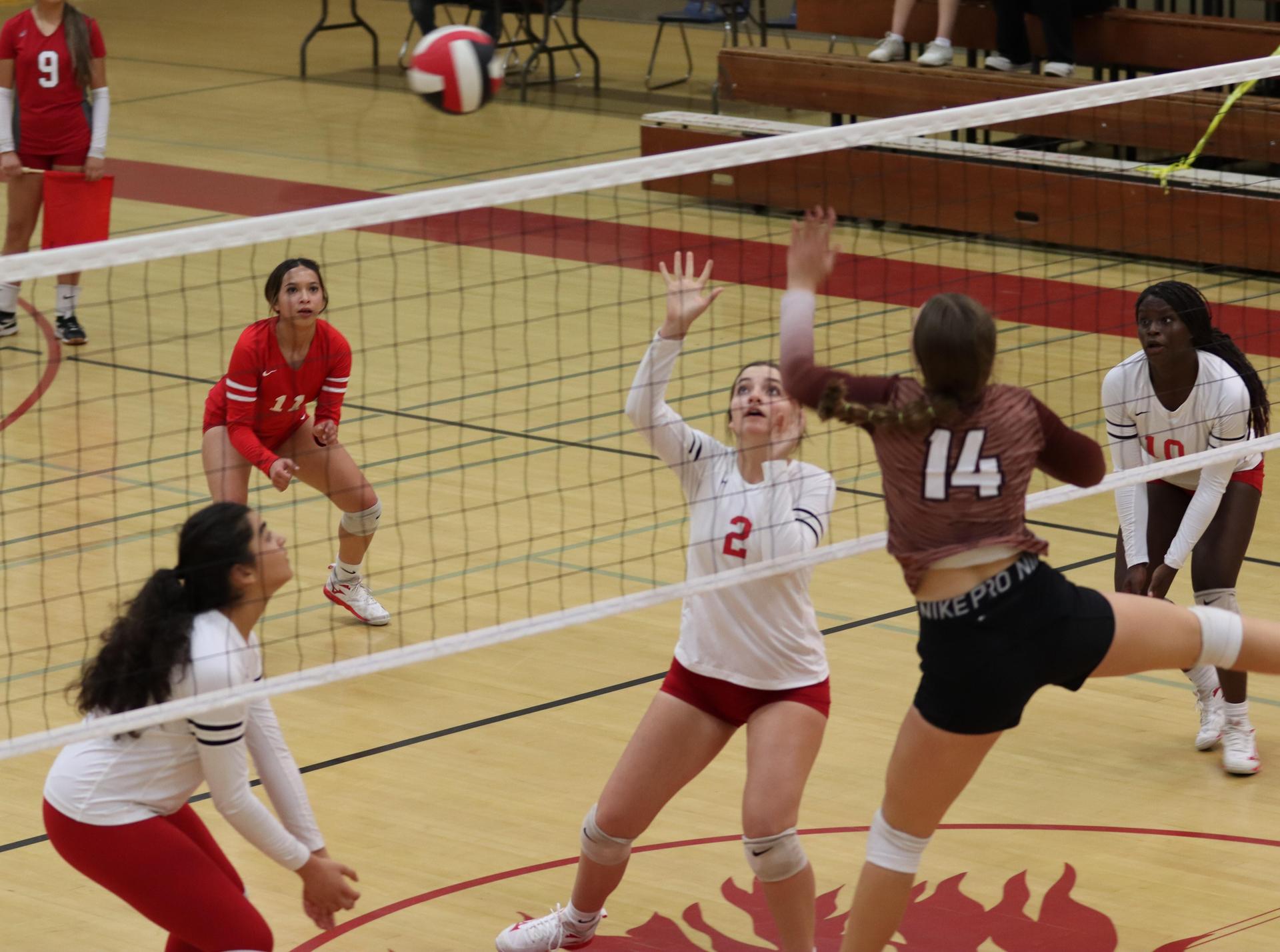 varsity volleyball players in action against Fresno Christian