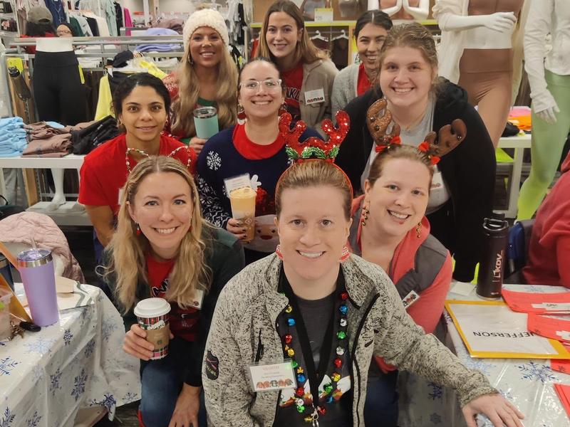A festive group of smiling individuals wearing holiday accessories.