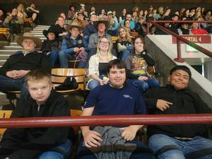 FFA members sitting together in the stands of the stadium watching the rodeo.