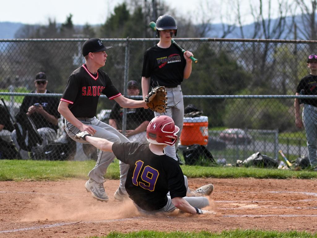 A baseball player sliding in to home base.