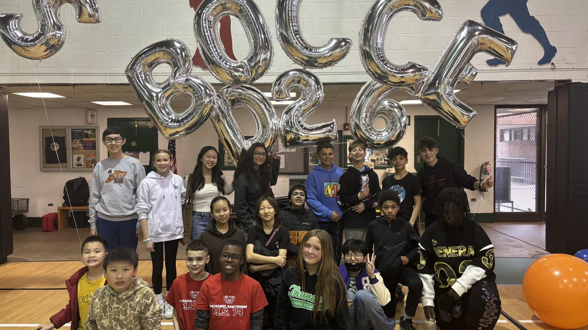 Group of people posing together with large 'Bocce' balloons.