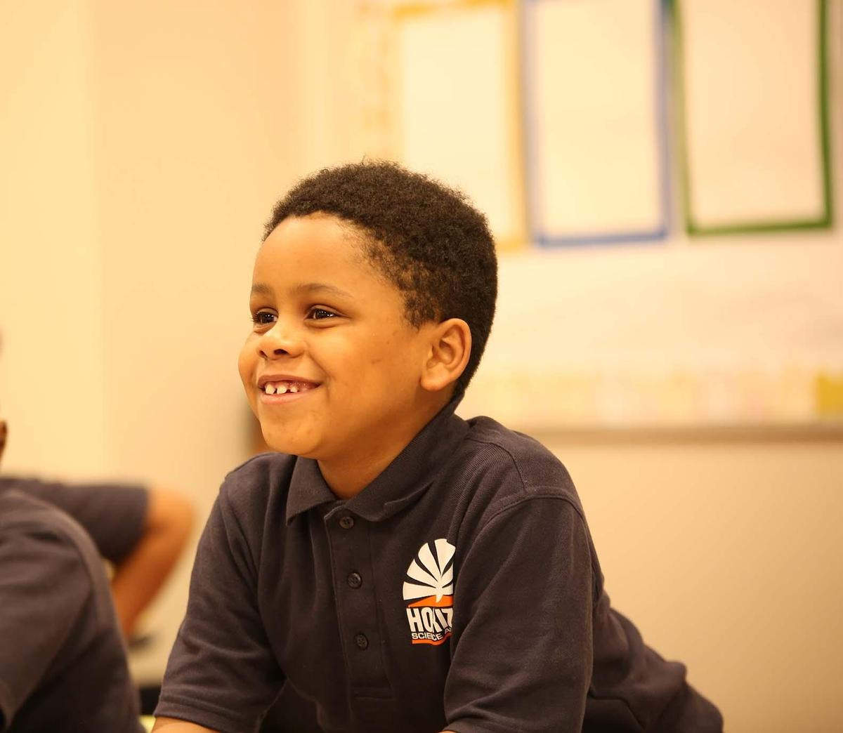 HSA Columbus Primary student wearing headphones uses a laptop in class