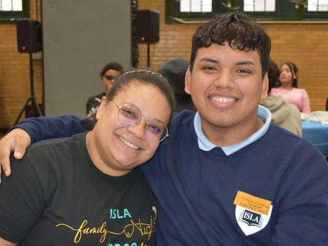 Two smiling individuals pose closely together, showcasing a joyful moment.