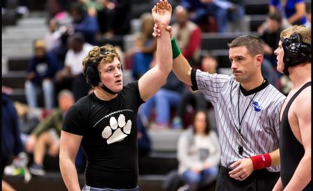 wrestler with hand in air showing a win