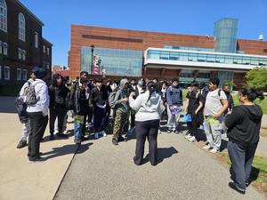 Group of students gathered outdoors near a school building.