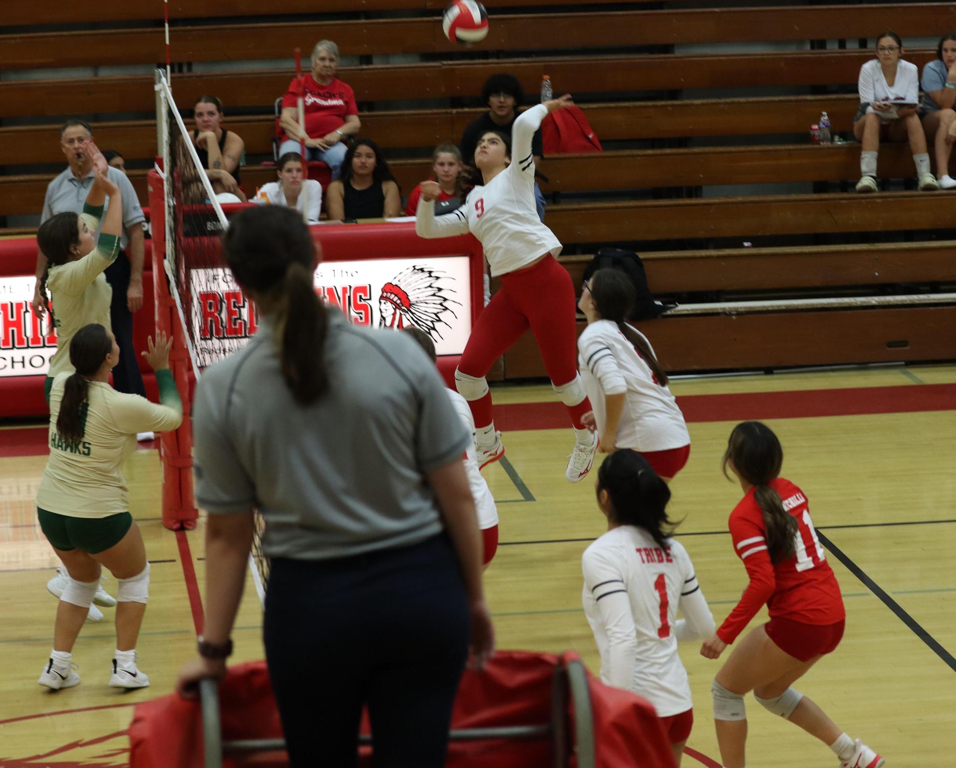varsity volleyball players in action against liberty