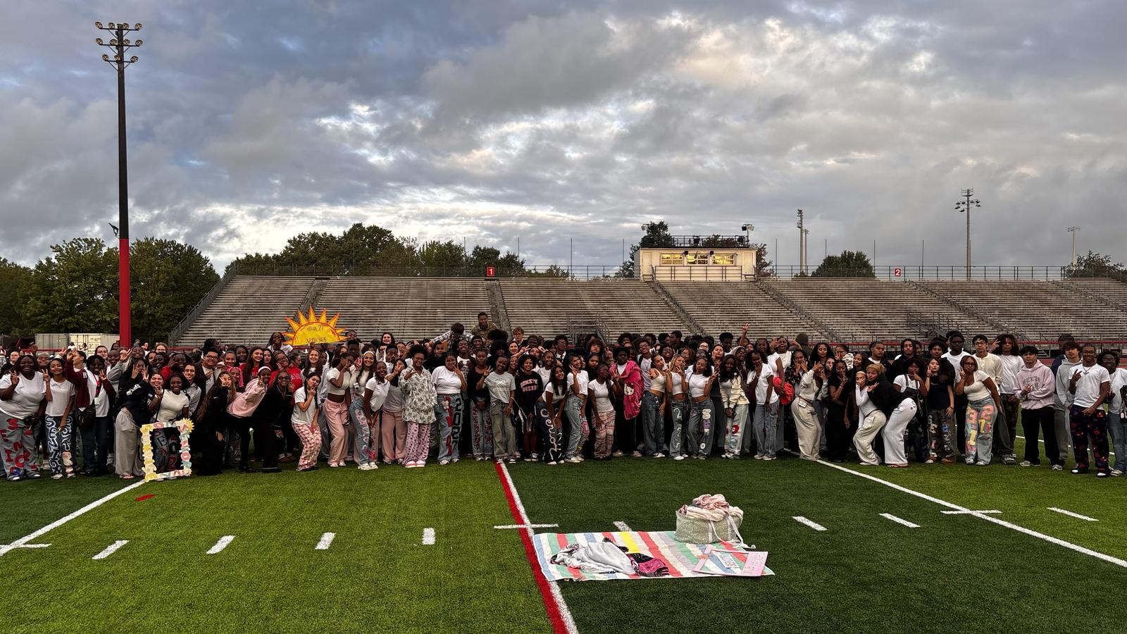 Group of students on the football field at sunrise