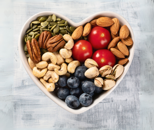 Heart-shaped bowl filled with healthy snacks