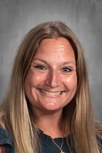 Smiling woman with long blonde hair in a blue top.