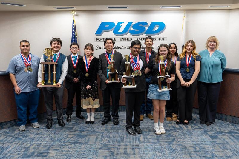 Harmony Magnet Academy's Academic Decathlon team poses with their trophies and medals at the PUSD Board meeting after winning their fourth consecutive Tulare County championship.