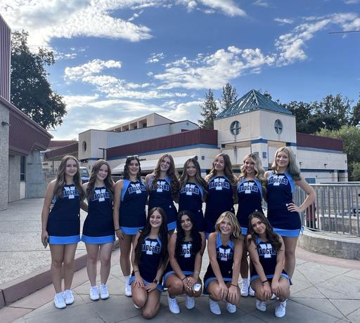 Cheerleaders posing in front of a school building