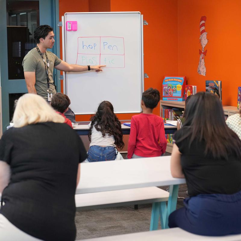 Staff member leading a small group reading activity