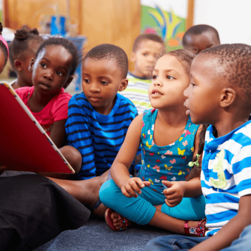 STUDENTS SITTING ON THE FLOOR DURING READING TIME