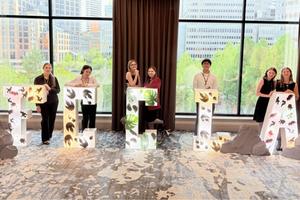 Students competiting in the FCCL state contest standing behing FCCLA letters in front of a window