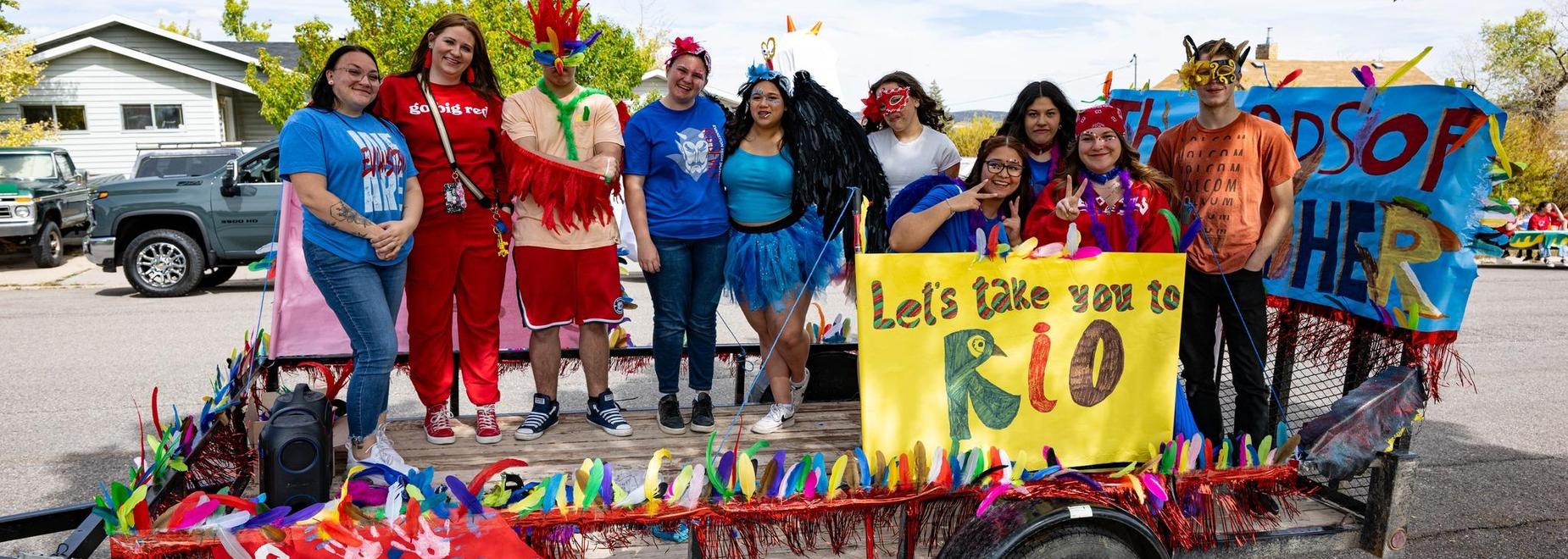Group of people in costumes on a parade float.