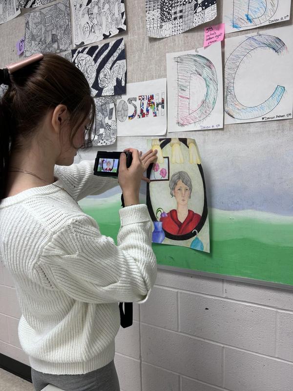 Photo of a student taking a picture of art