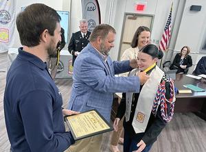 Director of Schools Dr. Jimmy Sullivan (foreground) and CTE assistant director Brian Lewis present an RCS Distinguished Graduate Award to one cadet.