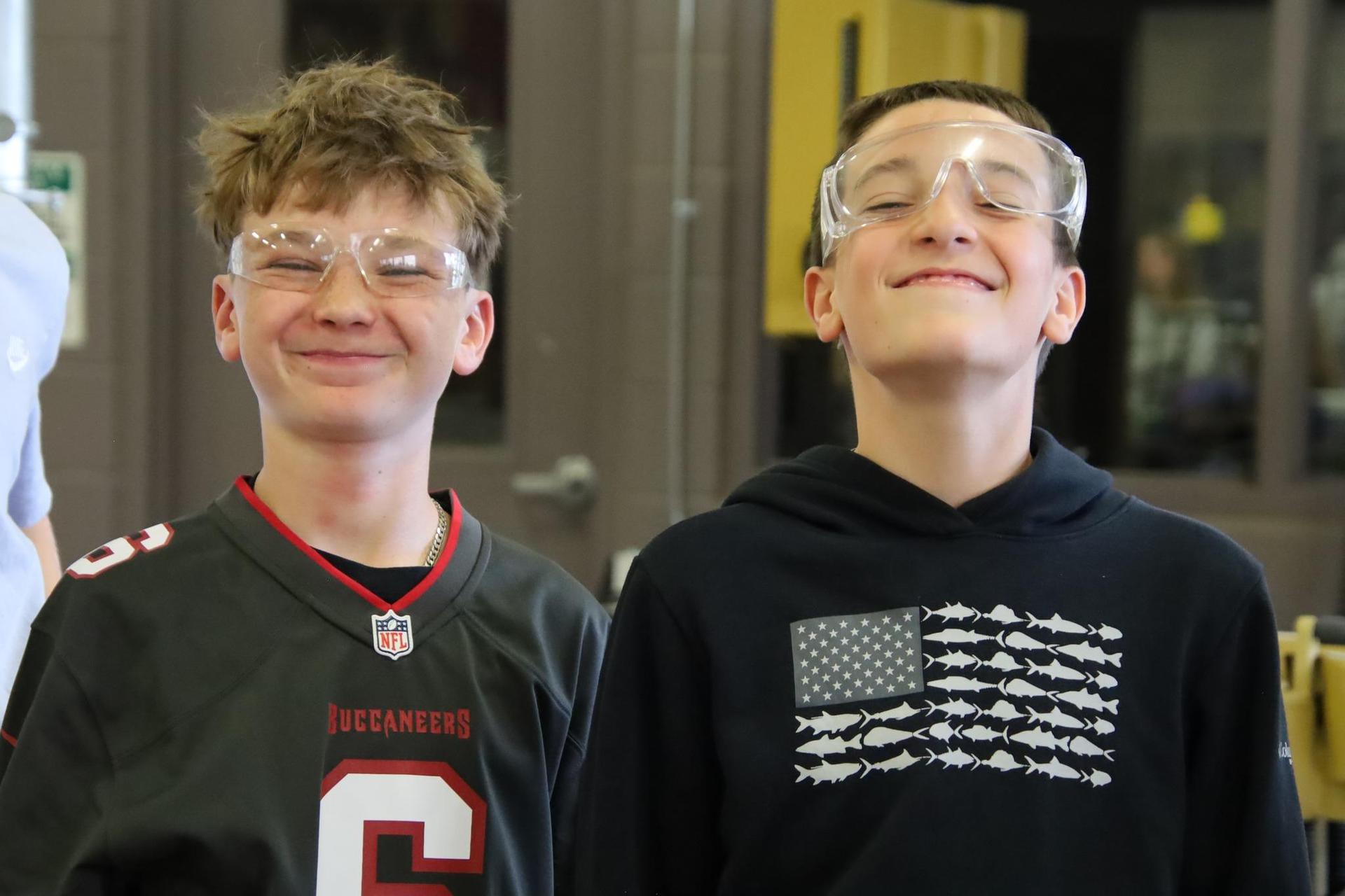 Two students smiling in a wood shop classroom