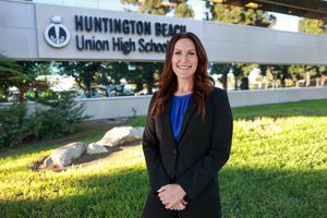 Mrs. Sabol stands outside confidently on a sunny day in a black suit