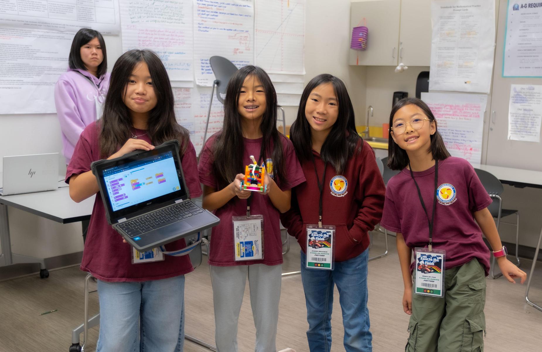 5 students in classroom posing for photo