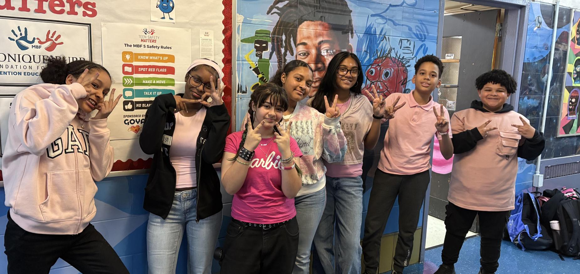 Group of students dressed in pink standing in a hallway