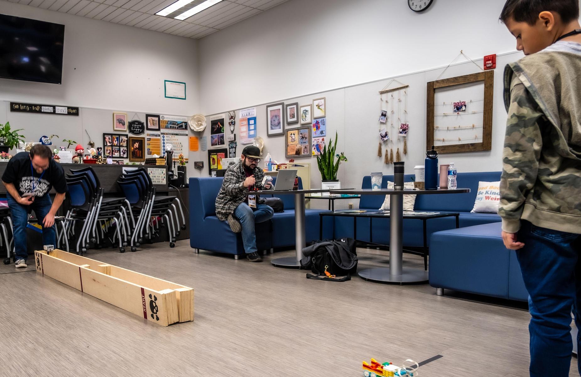teachers work with student and his robot