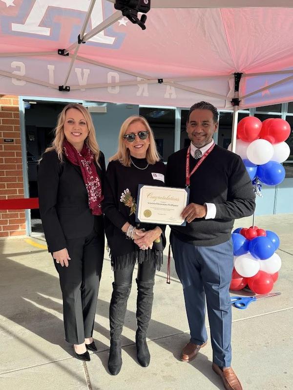 photo of mayor with superintendent and principal underneath a canopy. They are holding a certificate that reads Congratulations