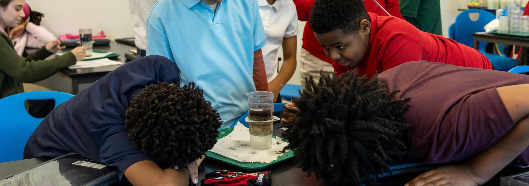 Middle school students observe a science experiment
