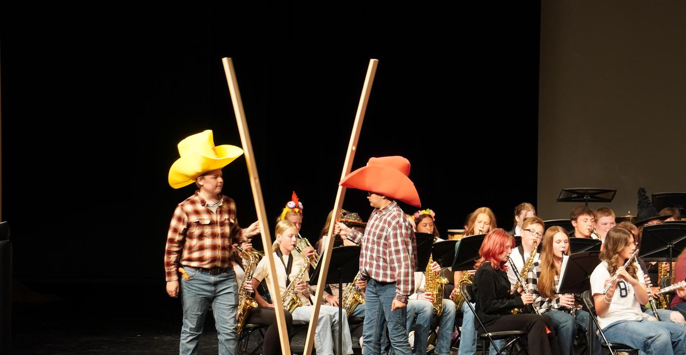 TKMS students have some fun during their final spring band concert. Two boys are wearing giant foam cowboy hats and "playing" giant-sized sticks.