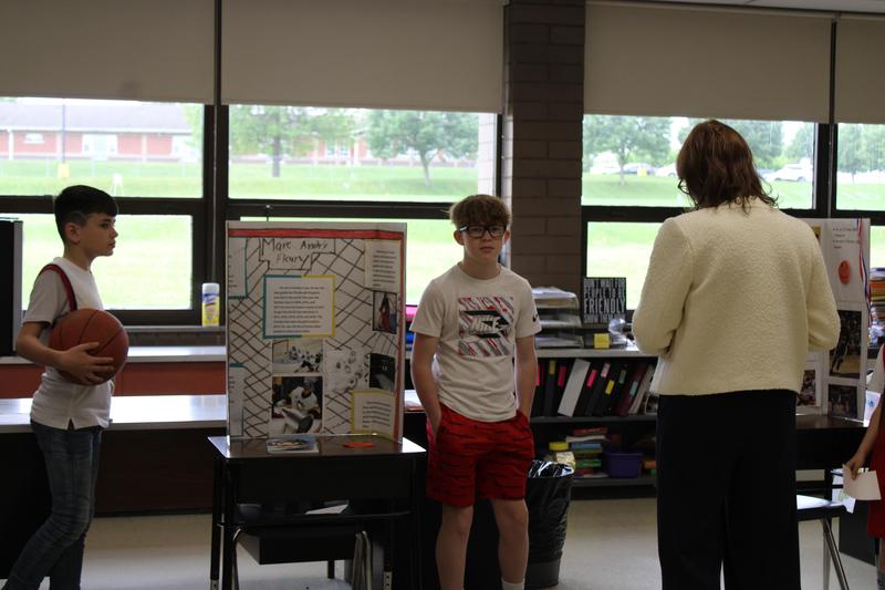 students dressed in character present information to principal