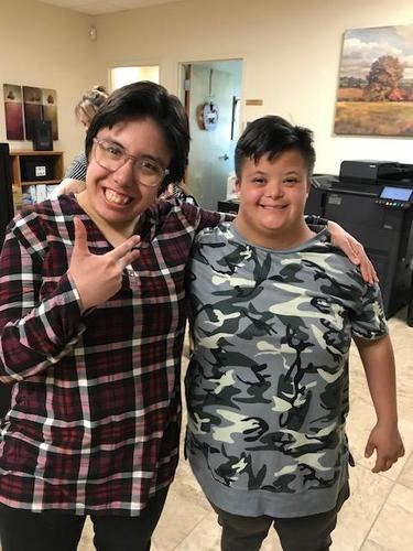 Two smiling friends posing together in a casual setting.