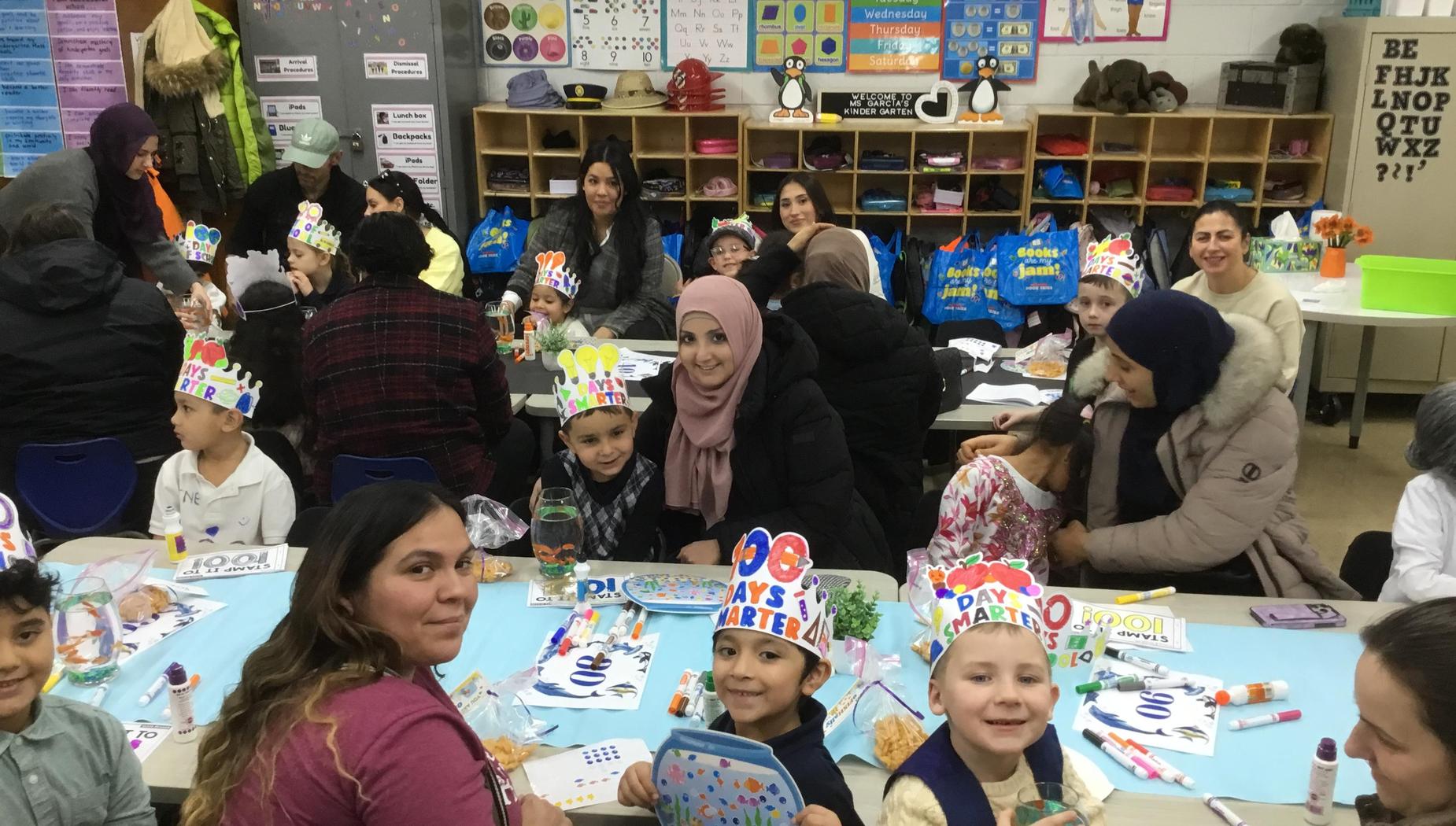 Children and adults celebrate together at a festive gathering with party hats.