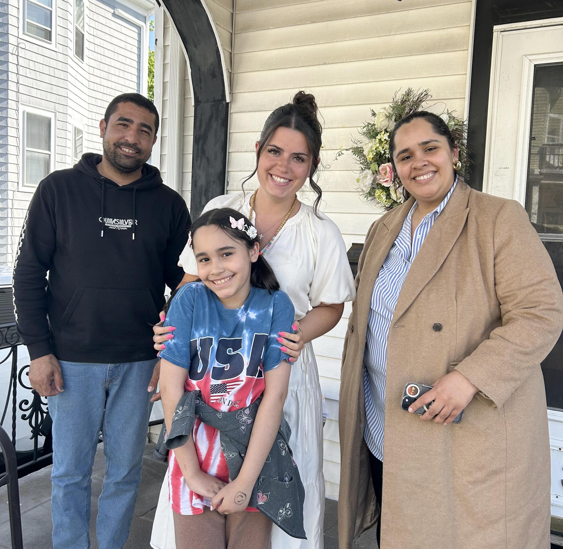 A teacher, a young student, and parents, on a front porch