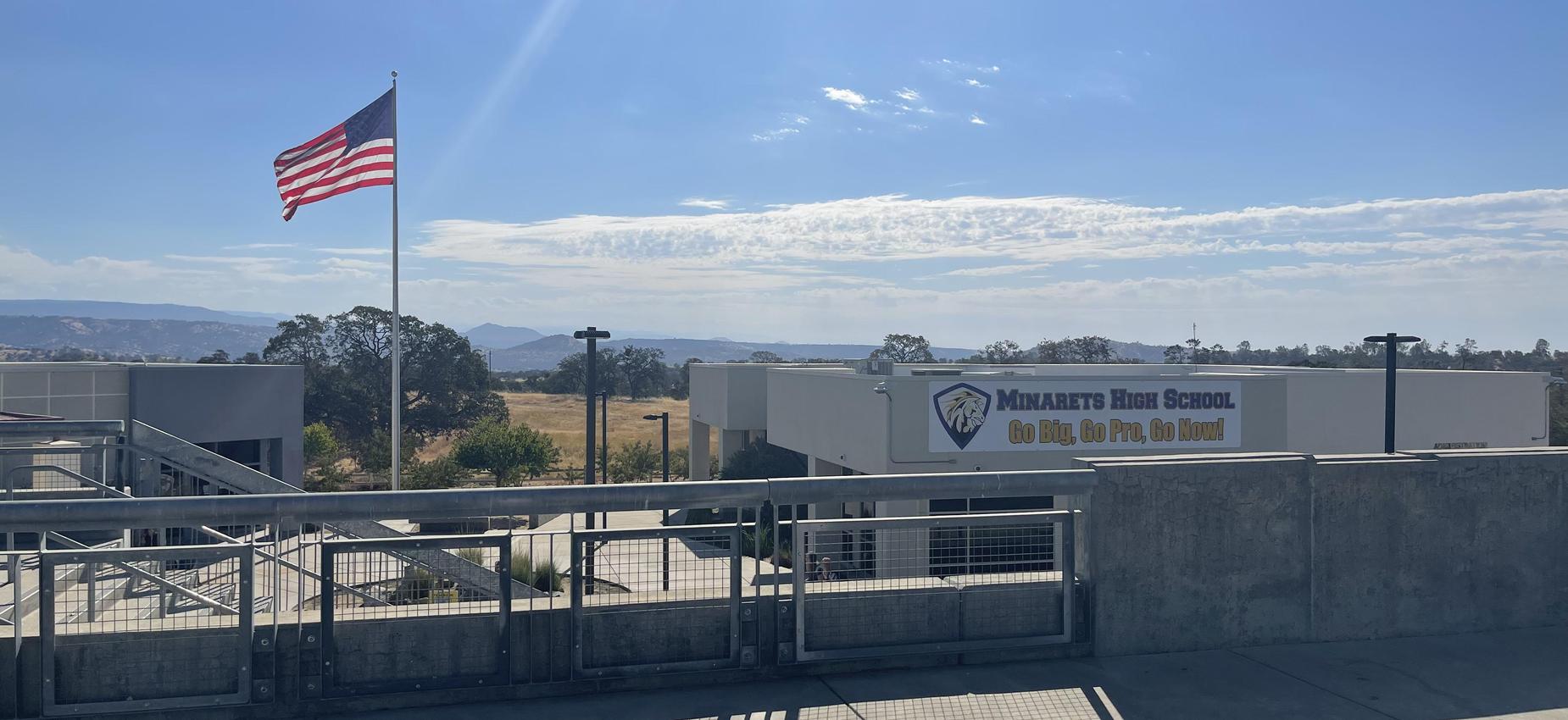 View of Minarets High School with an American flag and mountain backdrop.