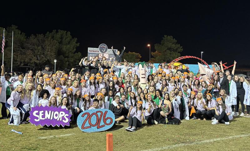 Large group of students celebrating their graduation with decorations at night.