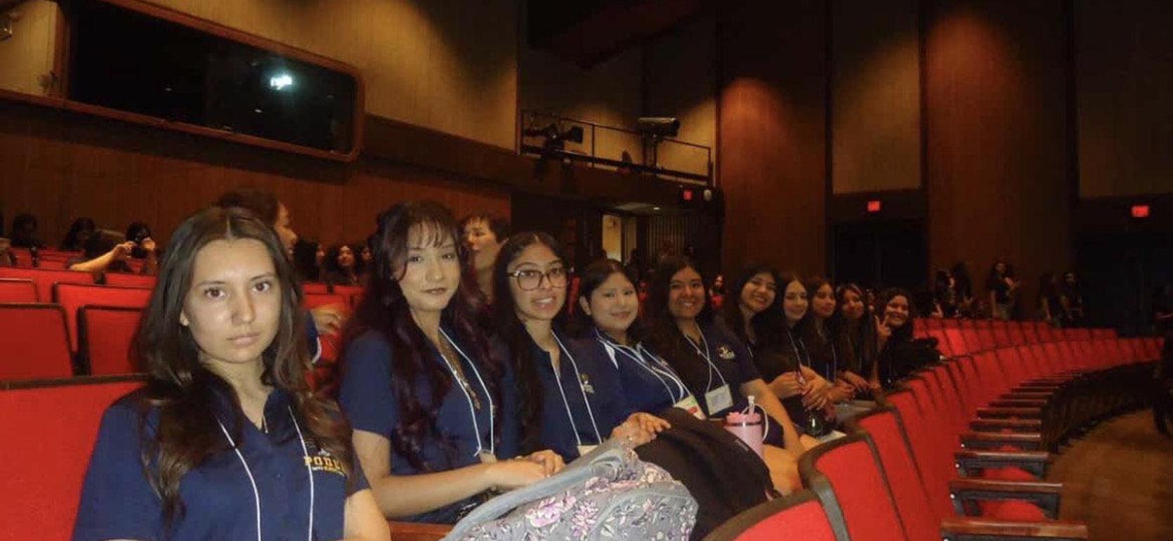 A group of students sitting in an auditorium, facing the camera.