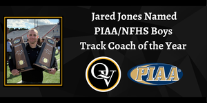 Image depicts a smiling man holding two large trophies while on the field and includes the headline "Jared Jones named PIAA Boys Track Coach of the Year"