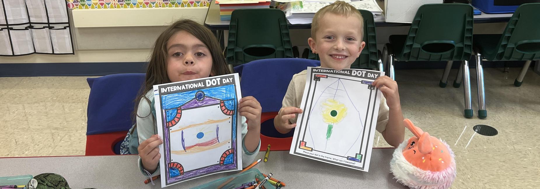 boy and girl showing the pictures they drew