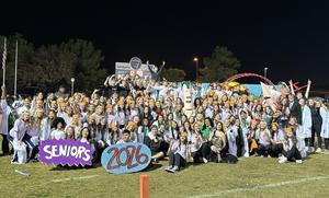 Large group of students celebrating their graduation with decorations at night.
