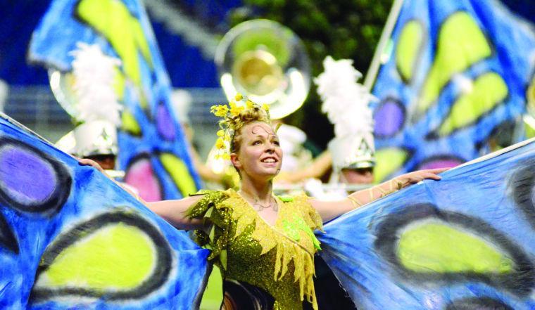 girl wearing colorful butterfly costume performing on field