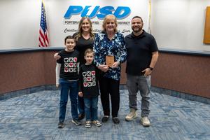 Dawn Griffin holds her recognition award and poses with family at the PUSD Board meeting.
